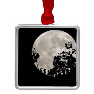 Moon behind dark leaves christmas ornament