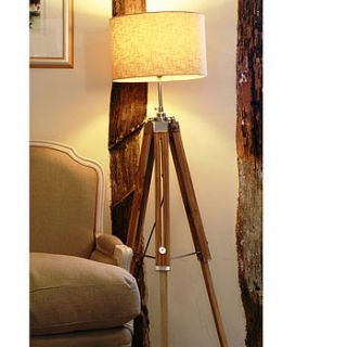 natural wooden tripod floor lamp by candle and blue