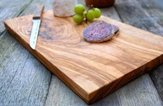 natural wooden serving or chopping board by the rustic dish